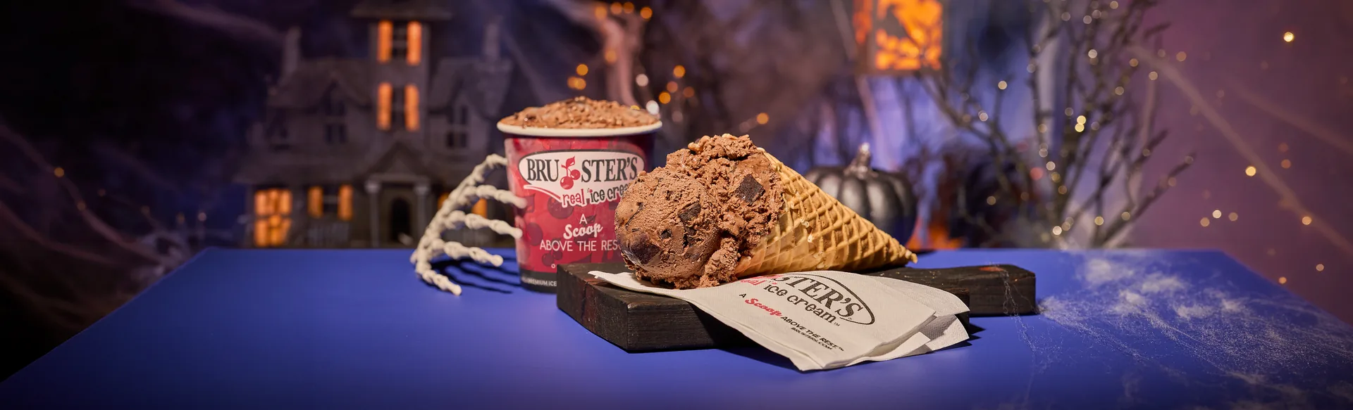 Bruster’s chocolate ice cream in a waffle cone beside a branded take-home cup